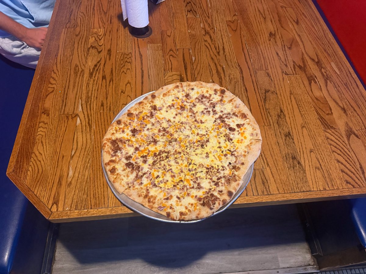 A full pie on a metal pan on a wood table in the booth area